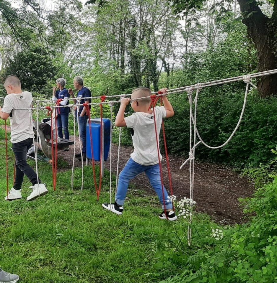 touwen met lussen hangen tussen bomen. Twee kinderen klimmen in de touwen