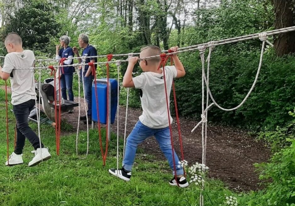touwen met lussen hangen tussen bomen. Twee kinderen klimmen in de touwen